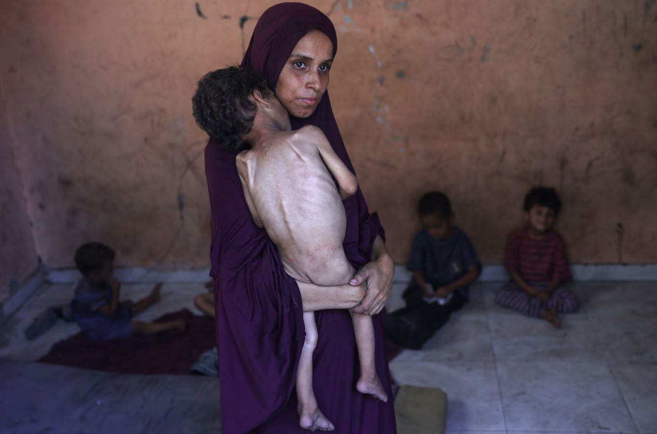 Imagem do dia 23 mostra Naeema, palestina de 30 anos, segurando seu filho de dois anos, Yazan, nos braços em um campo de refugiados em Gaza