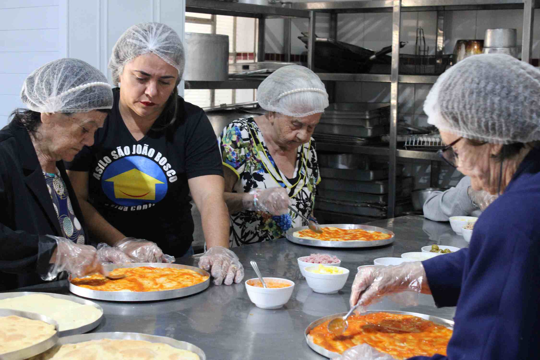 Durante a manhã, os idosos participaram de uma oficina de pintura, onde decoraram o espaço com ilustrações de pizzas.