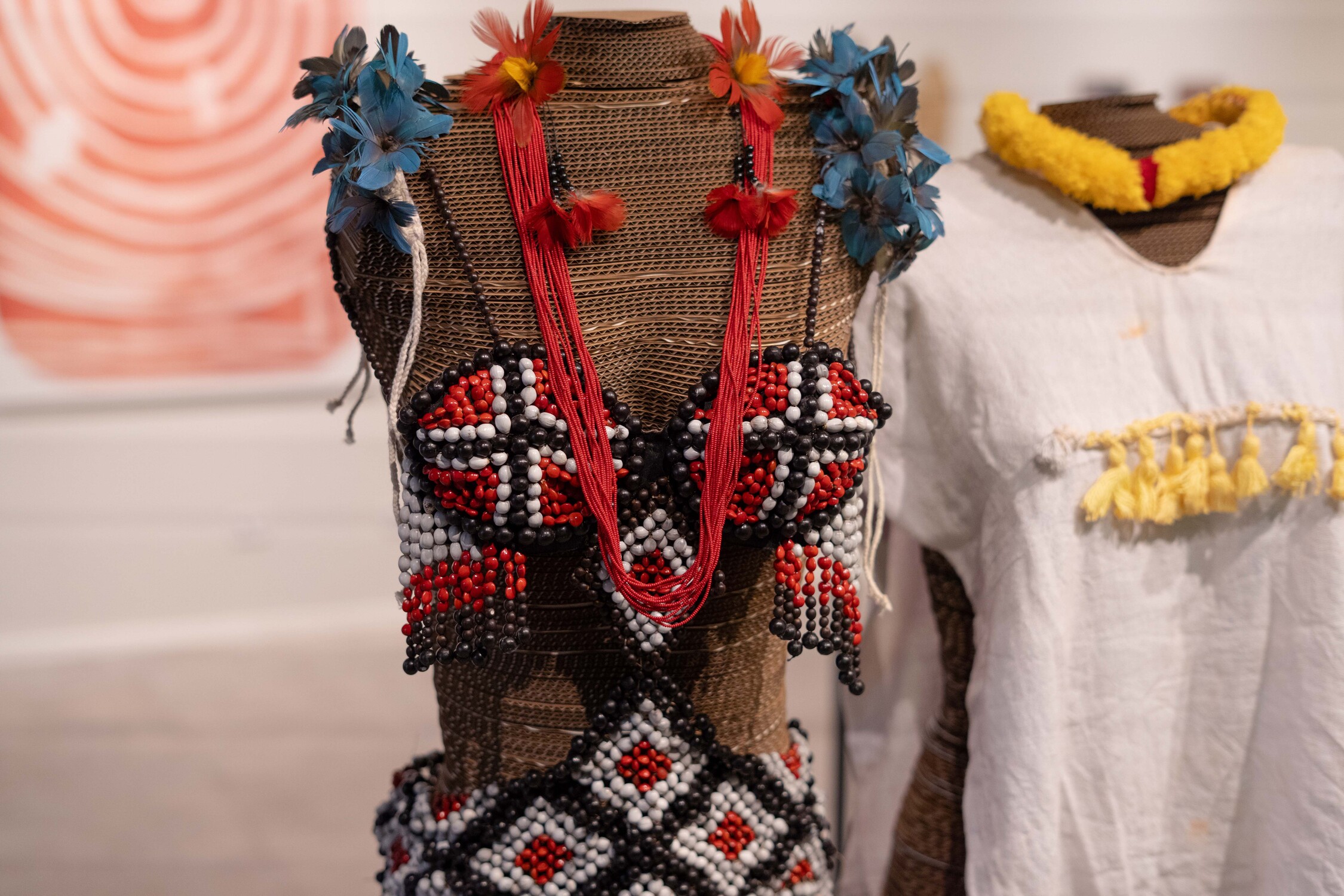 Colar e adorno tradicional indígena em exibição na mostra.