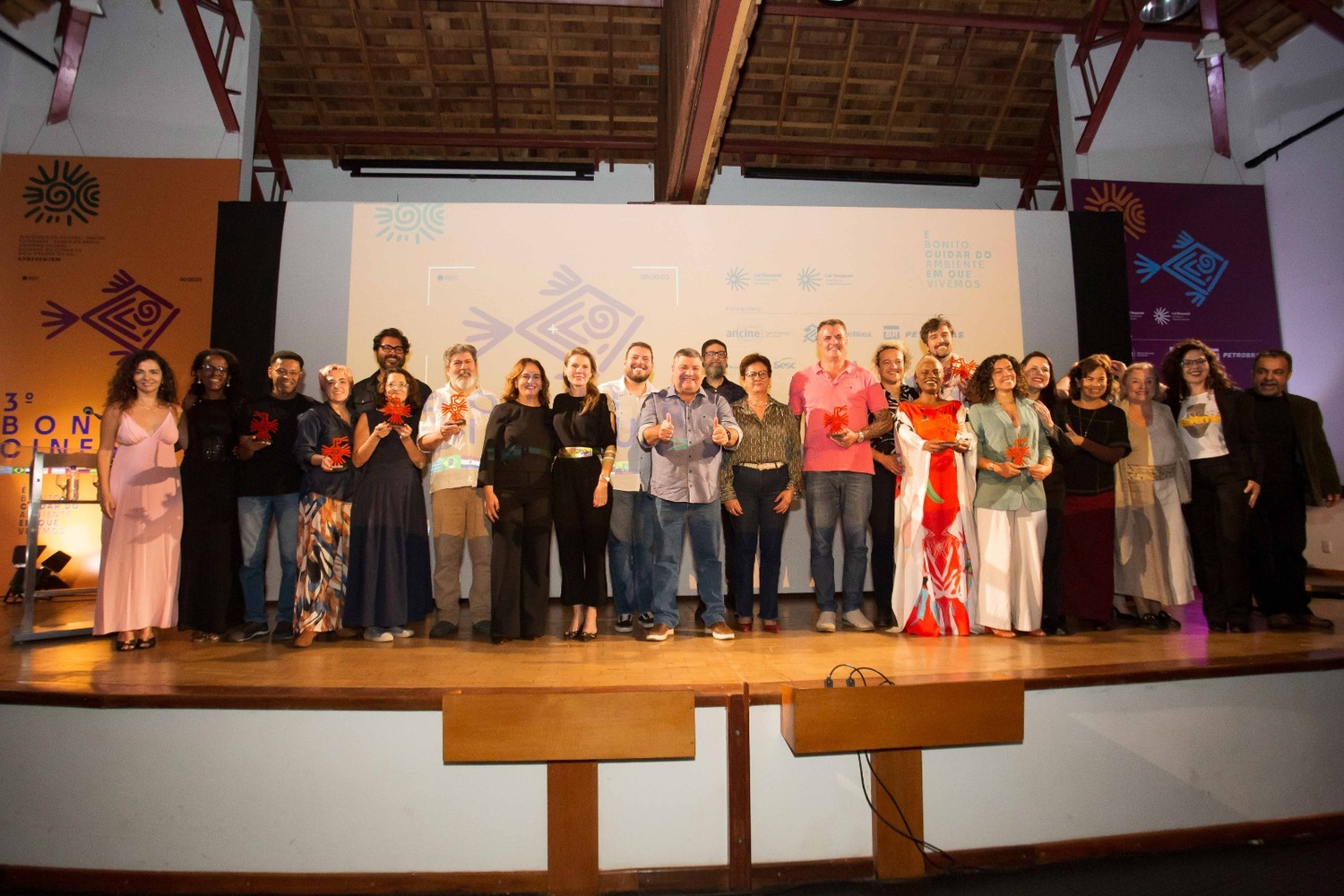 Premiados posam juntos no palco após anúncio dos vencedores.