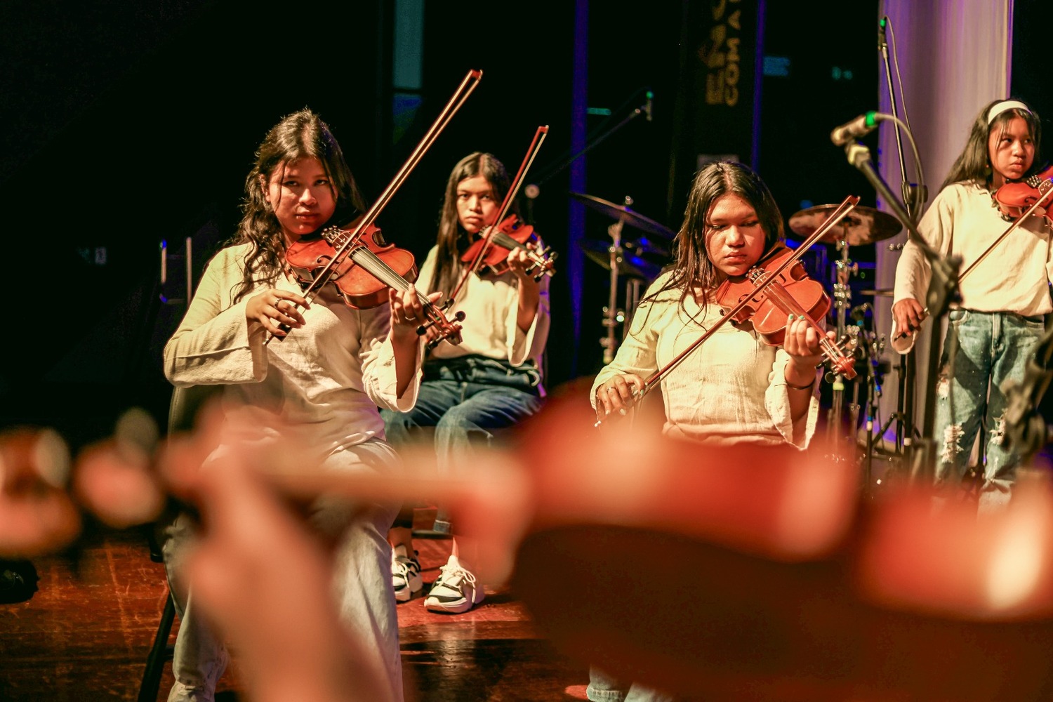 Maestro Eduardo Martinelli conduzindo ensaio com jovens músicos de diferentes etnias