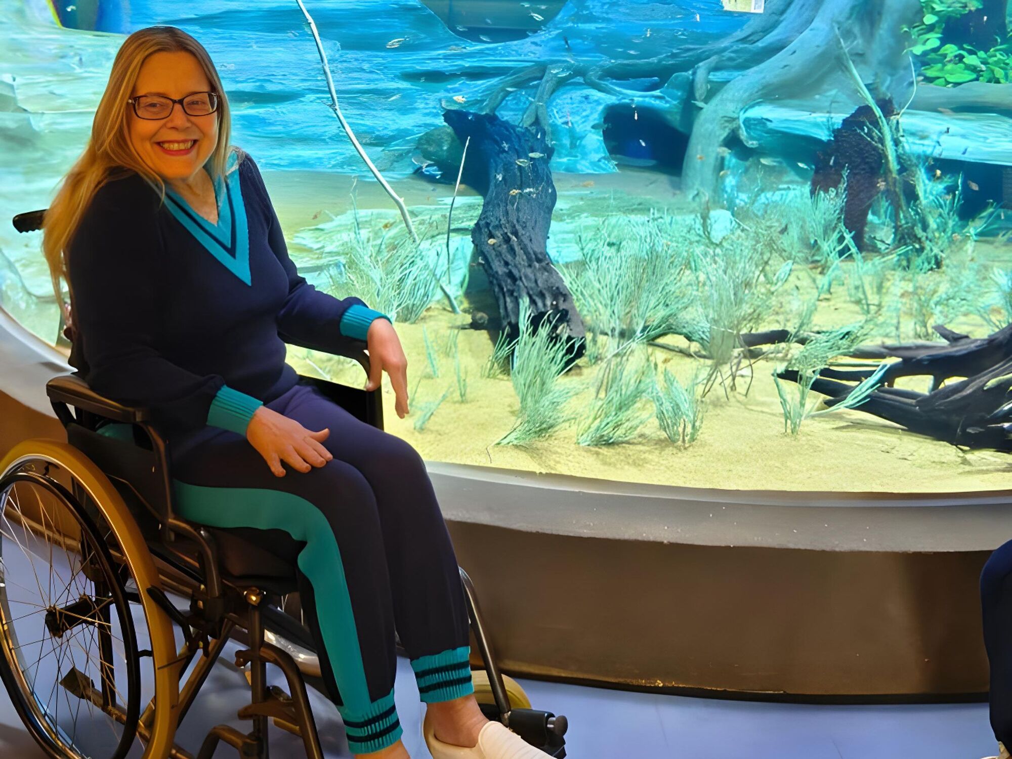 Sorridente, Giselle observa o aquário no Bioparque Pantanal em um dia marcado por afeto e cuidado.
