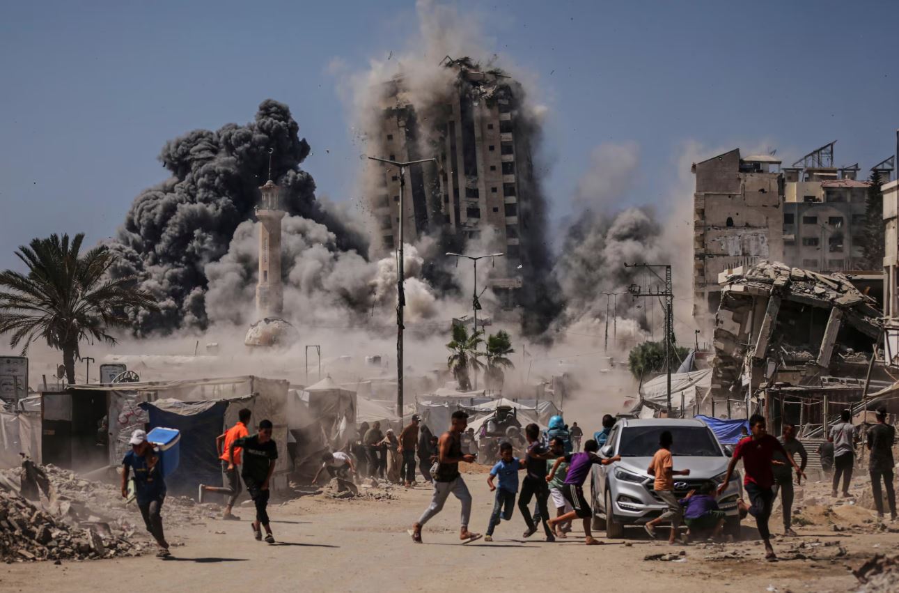 Palestinos correm para se proteger durante um ataque aéreo israelense a um prédio alto na Cidade de Gaza, sexta-feira, 5 de setembro de 2025, após Israel emitir um alerta.