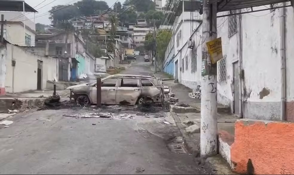 Barricada incendiada em rua do Complexo do Alemão durante operação de forças de segurança na manhã desta terça-feira (28)