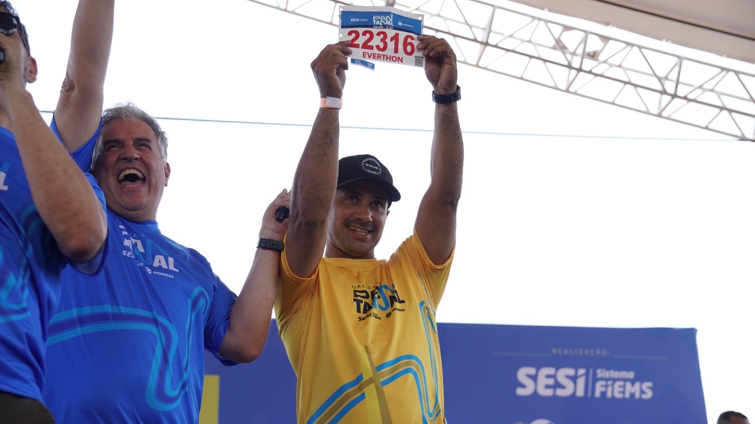 Everthon Aranda levanta o número sorteado com orgulho e emoção após ser anunciado como o ganhador do carro na Corrida do Pantanal. (Foto: Divulgação)