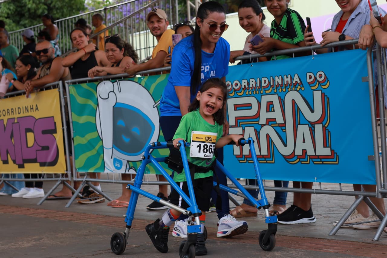 Caick, de 4 anos, com paralisia cerebral, cruza a linha de chegada com ajuda do andador e contagia o público com sua alegria durante a Corrida Kids.