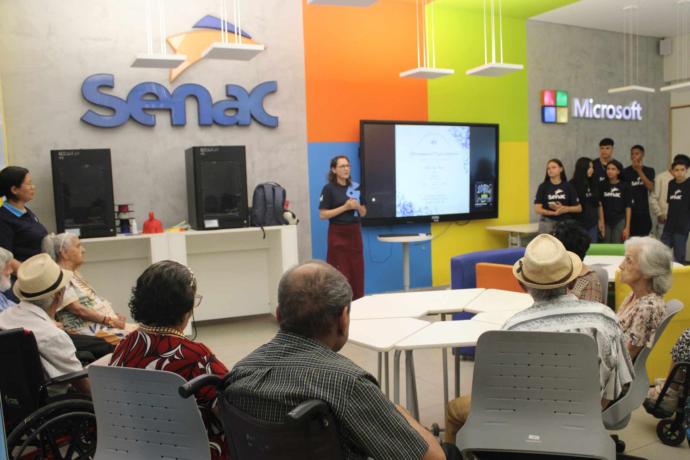 Grupo de idosos acompanha apresentação no Senac Hub Academy em atividade que uniu juventude, tecnologia e afeto.