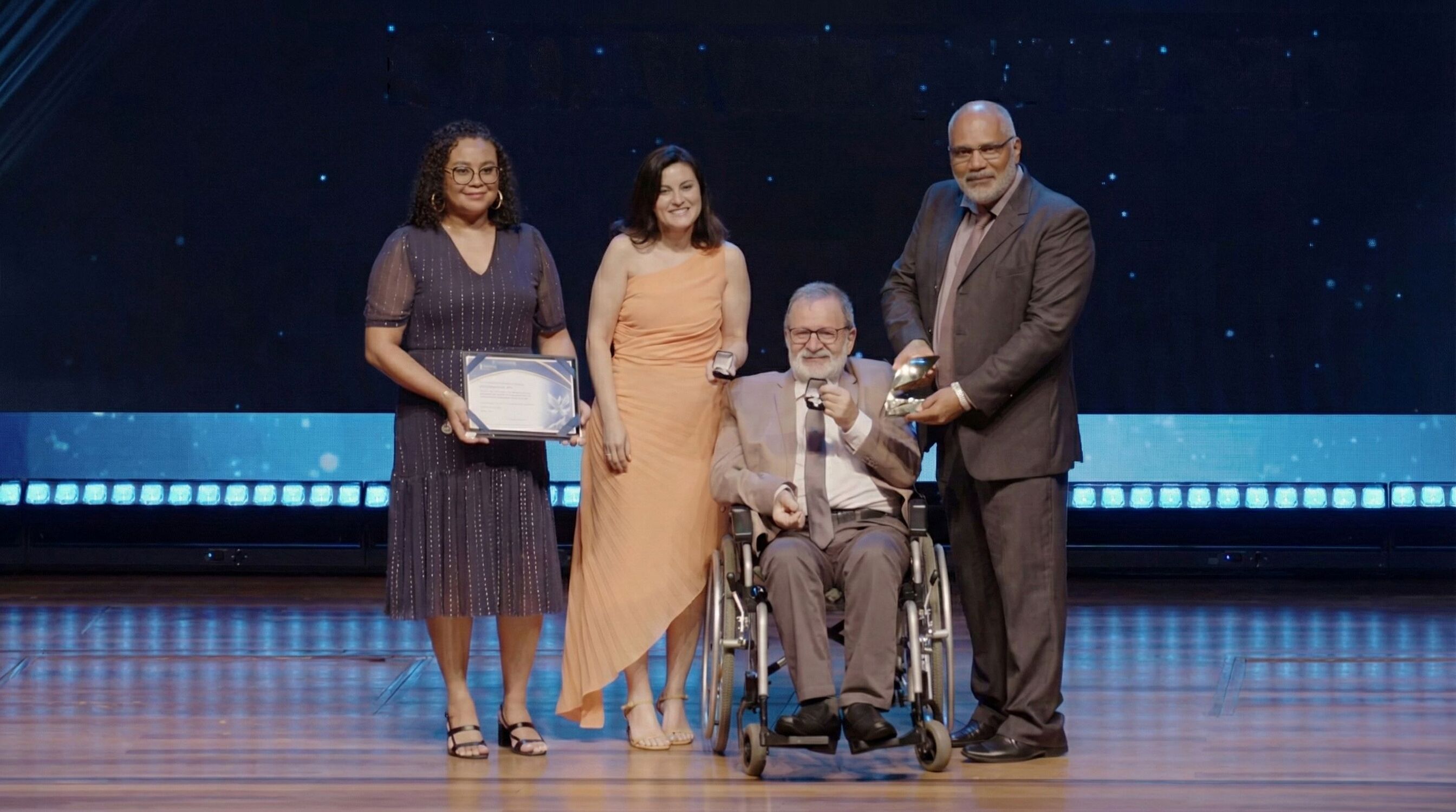 Durante a premiação do Prêmio Atena 2025, Edison Araújo entrega reconhecimento ao Sindivarejo Naviraí, representado pelo presidente Onivaldo Serafin, ao lado da secretária-executiva do sindicato, Priscila dos Santos.