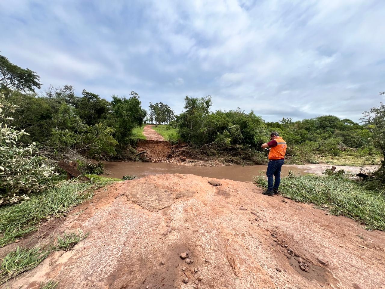 Equipe da Defesa Civil analisa local onde ponte foi levada pela chuva. Levantamento técnico deve embasar pedido de apoio ao governo estadual.
