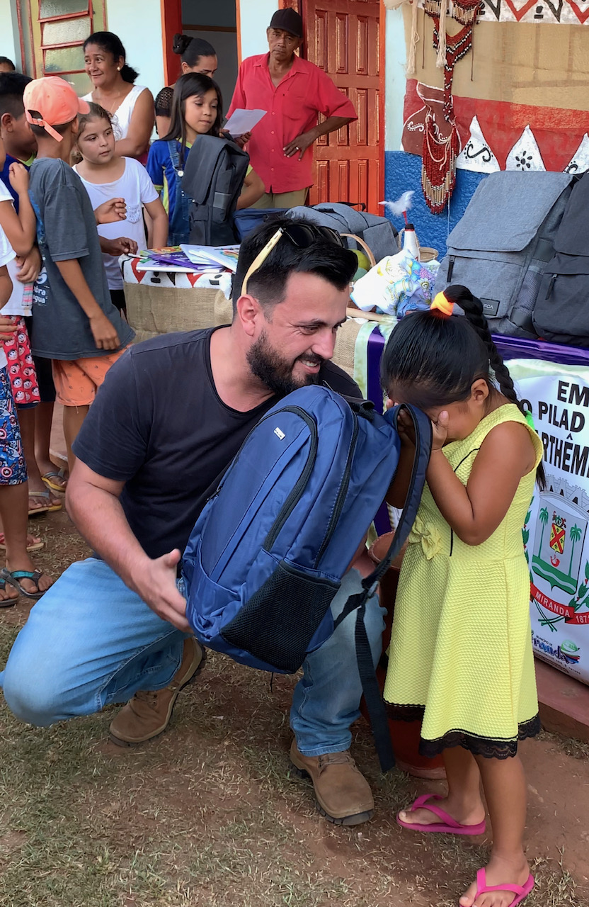O jornalista Leandro Gameiro realiza entrega simbolica de um Kit Escolar para uma das alunas da escola 