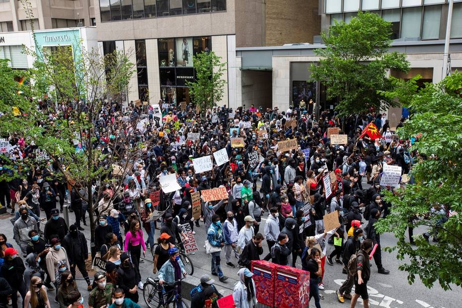 Manifestantes marcham para protestar contra as mortes nos EUA de Ahmaud Arbery, Breonna Taylor e George Floyd, e de Regis Korchinski-Paquet, de Toronto, que morreram após cair de um prédio de apartamentos enquanto policiais estavam presentes, em Toronto.